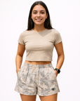 Woman wearing a beige top and RF-Wear Women's Tree Camo Shorts in Cream/Grey 